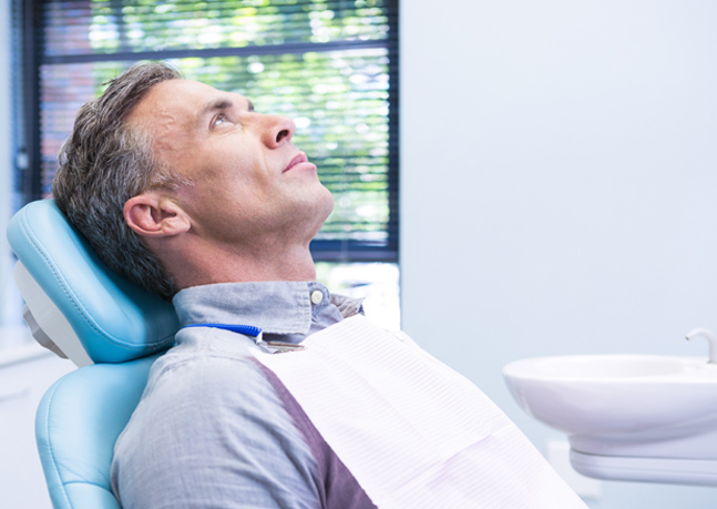man waits for screening in dentist office