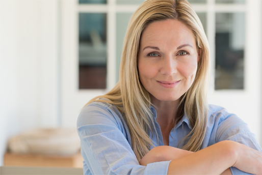 blonde woman with arms crossed at home smiling